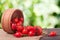 Rosehips in wooden bowl on a dark board with sackcloth and blurred background