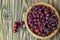 Rosehips in a wooden bowl on a wooden surface. Rosa canina hips