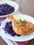 Rosemary baked chicken drumsticks with spice-crusted skin served with braised red cabbage and creamy mashed potatoes on plate