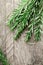 Rosemary plant on wooden rustic table from above, fresh organic herbs with copy space for text.