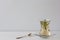 Rosemary tea in Armudu glass with branch of rosemary in it and spoon on the table on white background