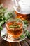 Rosemary tea in glass tea cup on rustic wooden table closeup. Herbal vitamin tea