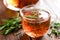 Rosemary tea in glass tea cup on rustic wooden table closeup. Herbal vitamin tea