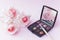 roses with makeup brush eyeshadow palette pink backdrop. High quality photo