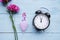 Roses, pills and sanitary cup with alarm clock