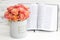 Roses in a round box and the Bible. Beautiful pink roses on a white wooden background. Beautiful pink roses and the Bible.