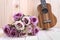 The roses with ukulele on wooden background