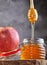 Rosh hashanah - jewish New Year holiday concept. Traditional symbols: jar of honey and apple on a gray background. Copy space for
