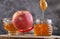 Rosh hashanah - jewish New Year holiday concept. Traditional symbols: jar of honey and apple on a gray background. Copy space for