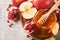Rosh Hashanah. Pomegranate, apples and honey traditional products for celebration on rustic grey background. Jewish Autumn Rosh