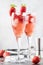 Rossini alcoholic cocktail with Italian sparkling wine, strawberry puree and ice in champagne glasses, place for text, selective