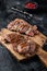 Rost Lamb leg fillet steaks, mutton meat with spices. Black background. Top view