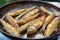 Rosy fried fish lies in a pan.