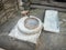 Rotary discoid mill stone for hand-grinding a grain into flour. Medieval hand-driven millstone grinding wheat. The