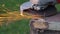 Rotary flex cutter cutting rusty nail on old wooden frame, sparks flying in air, closeup detail