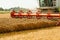 Rotary straw walker combine harvester cuts and threshes ripe wheat grain. Platform grain header with thresher reel