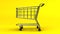 Rotated Shopping Cart On Yellow Background