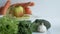 Rotating apple with measurement tape on a plate. Vegetables on the background. Footage starts with defocused view.