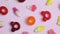 Rotating background of various jelly sweets, bears, donuts, candies, on pink background close-up top view concept
