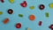Rotating background of various jelly sweets, bears, donuts, candies, sprinkles, dragees on blue background close-up top