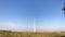 Rotating blades of wind turbine towers in blue sky