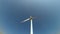 Rotating blades of a windmill propeller on blue sky background. Wind power generation. Pure green energy.