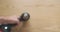 Rotating drill, close-up, on the background of a wooden tabletop. Top view, blurry. Demonstration of the operation of an