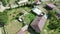 Rotating drone footage over rural houses on grass lawns and trees