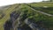 Rotating drone shot of a male walking on the sides of the high green mountains