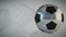 Rotating glossy soccer ball on white background - seamless looping