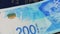 Rotating israeli money bills of 200 shekel and israeli passport - top view