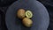 Rotating kiwi fruit on black background. Top view.