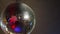 A rotating and sparkling disco ball on the ceiling in a dark room.