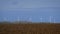 Rotating turbine towers on windmill field on blue sky background