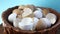 Rotating wooden bowl with broken egg shells on blue background