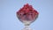 Rotation glass vase with a pile of ripe, juicy red raspberry.