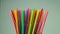 Rotation of many multi-colored plastic disposable straws for cocktails.