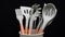 Rotation of silicone or rubber kitchen utensils on black background. Tools for cooking