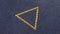 Rotation of a triangle made of yellow rhinestones on denim, the triangle symbolizes completion.