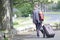 Rothesay, Isle of Bute / Scotland - June 21st 2019: Male tourist traveller with suitcase on wheels crossing road