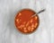 Rotini tomato soup in bowl with spoon on marble