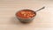 Rotini tomato soup in bowl with spoon on table