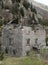 Rotten house without roof with falling walls in the mountains