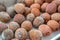 Rotten lychee fruit in a wooden drawer on a rustic wooden background. Fruits are covered with mold. Close-up