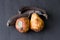 Rotten spoiled rotten fruits, bananas and pears. Black bananas on a black dark background. Damaged products, mold. Copy space for