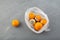 Rotten spoiled tangerines or oranges in plastic bag on grey background, top view. Ugly moldy fruit. Improper food storage. Concept