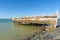 Rotting holed hulk of old wooden fishing boat beached