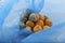 Rotting tangerines in blue plastic bag, close-up. Improper food storage. Concept - reduction of organic waste