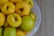 Rotting yellow apples, shriveled apples that have been sitting in a bowl for a long time