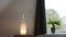 Rough big selenite crystal tower pole lamp illuminated on wooden night stand in home bedroom, spiritual home decor .